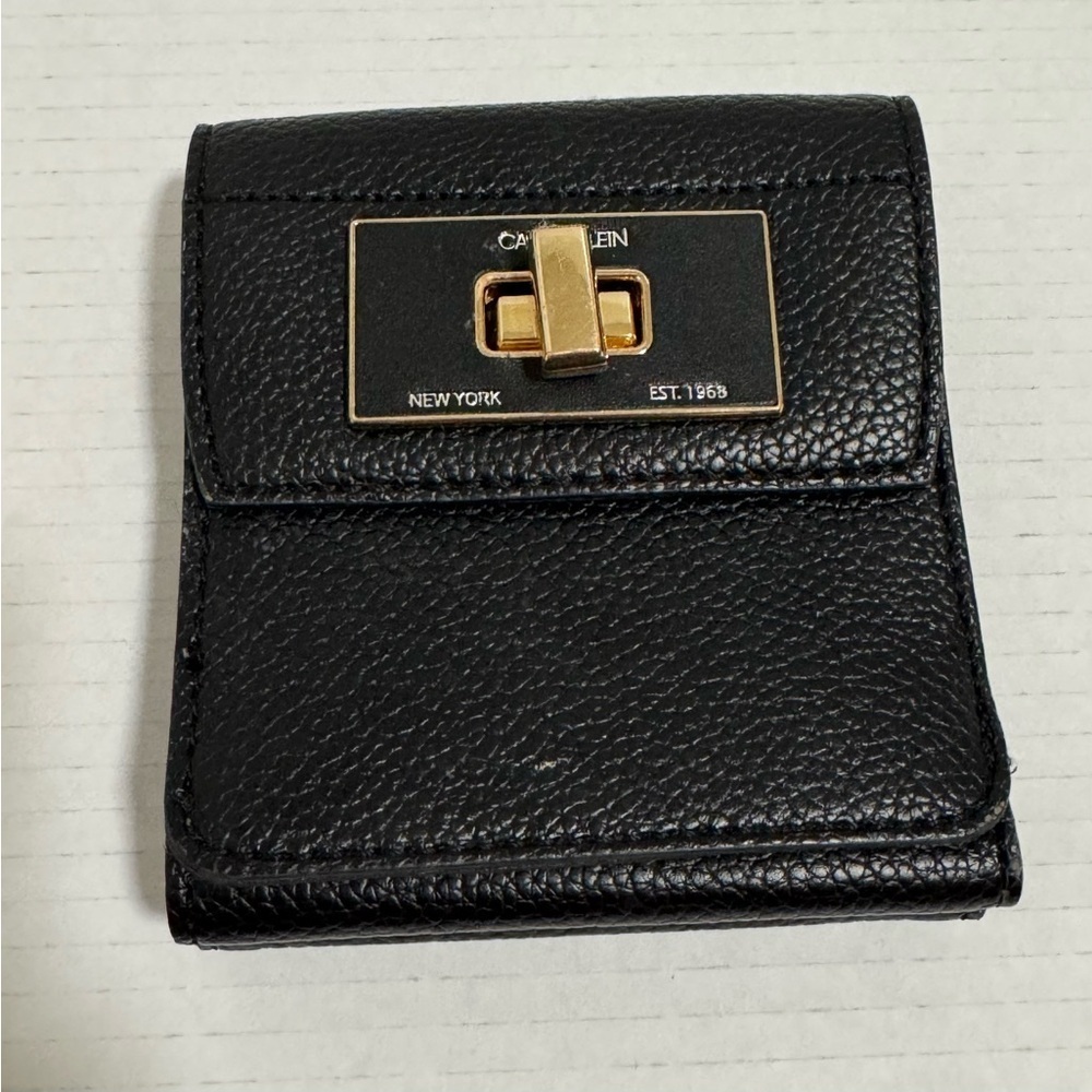 Calvin Klein black trifold wallet with a gold-tone metal closure